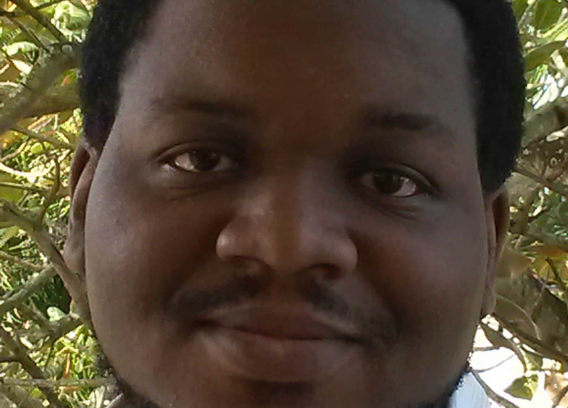 Close-up portrait of Ararimeh Aiyejina smiling in front of a tree.