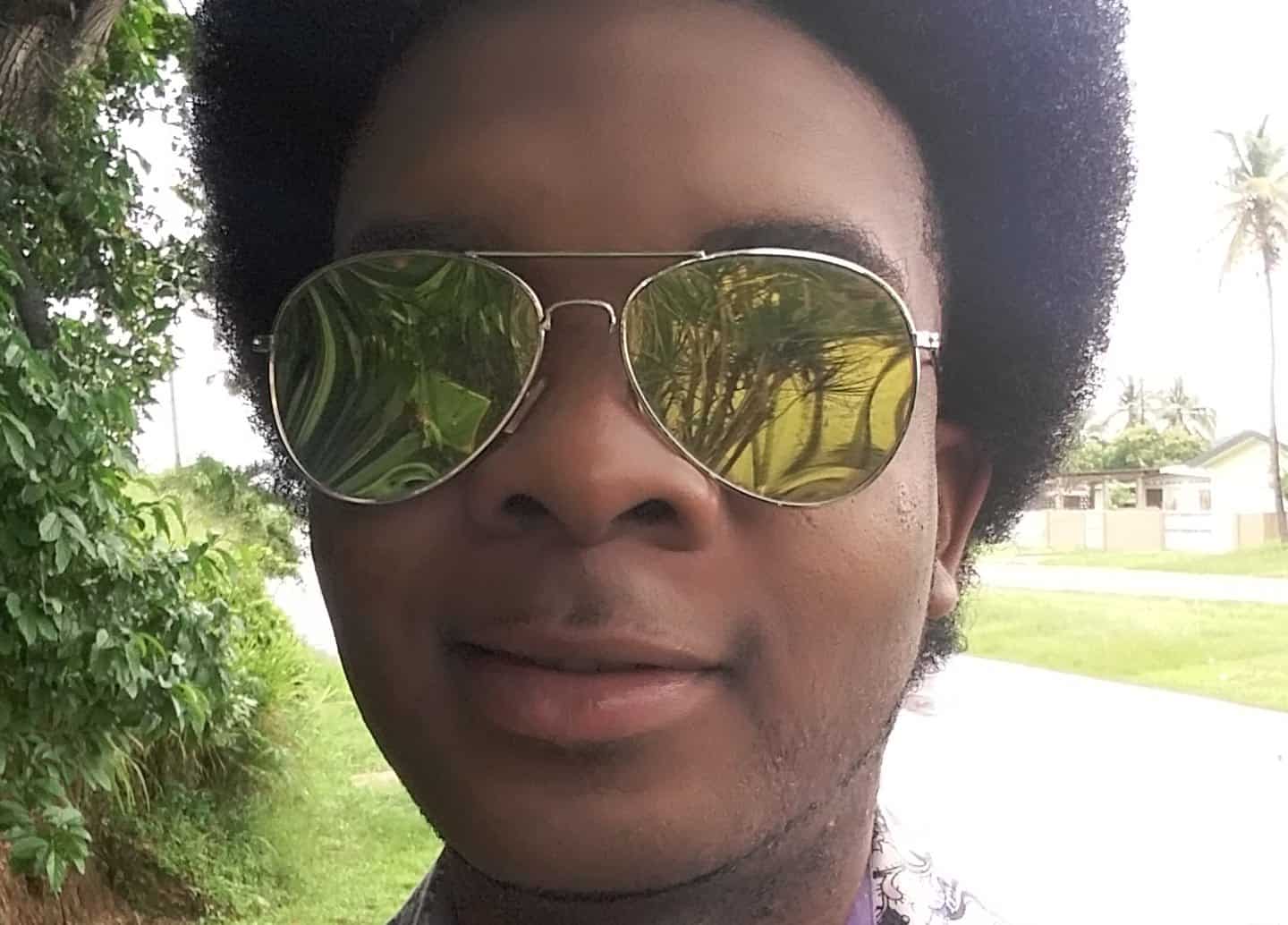 Perspective the Entertainer wearing gold-mirrored aviator sunglasses outdoors.