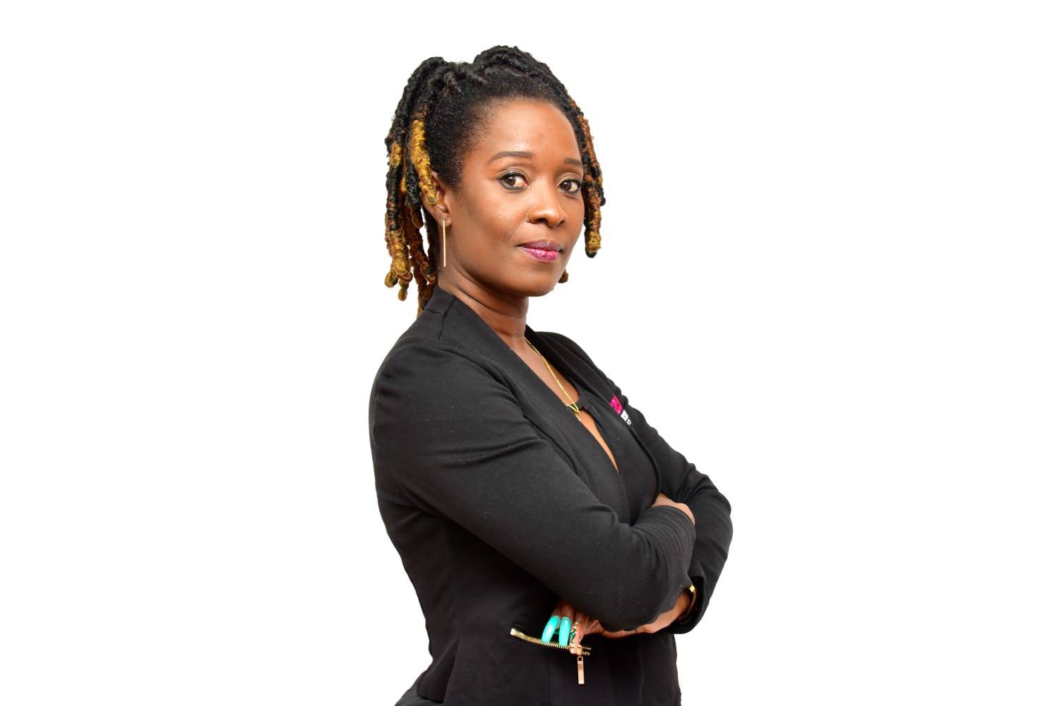 A woman in a black jacket with her arms folded, looking towards the camera.