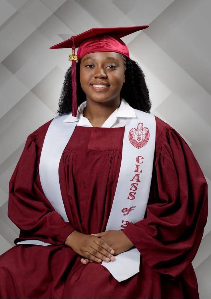A young woman wearing a maroon graduation cap and gown with a white stole that reads “Class of 2026”.