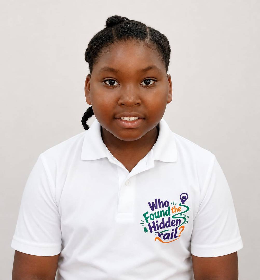 A girl wearing a white polo shirt that reads “Who Found the Hidden Tail?”.